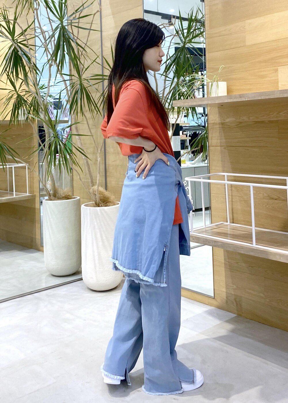 ホワイト系のスニーカー、ブルー系のパーカー、ブルー系のデニムパンツを着用したレディースの秋コーディネートの5枚目の写真