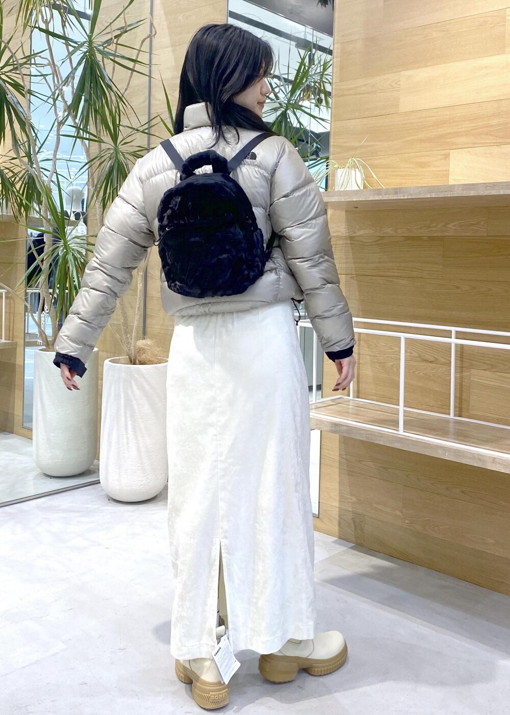 ベージュ系のダウンジャケット/コート、ホワイト系のブーツ、ホワイト系のスカートを着用したレディースの冬コーディネートの3枚目の写真