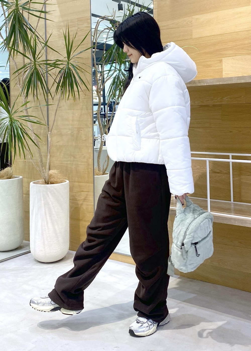 ブラウン系のその他パンツ、ホワイト系のスニーカー、ホワイト系のダウンジャケット/コートを着用したレディースの秋コーディネートの3枚目の写真