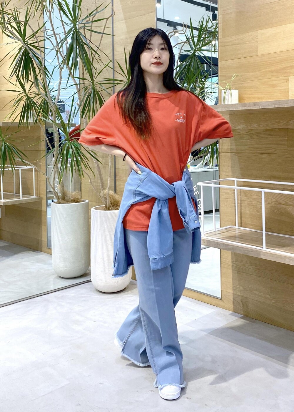 ホワイト系のスニーカー、ブルー系のパーカー、ブルー系のデニムパンツを着用したレディースの秋コーディネートの6枚目の写真