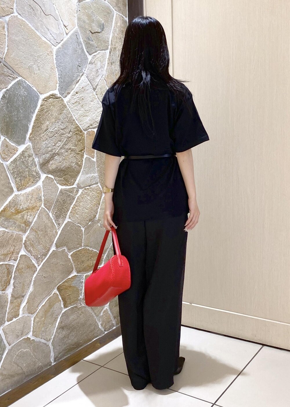 ブラック系のパンプス、ブラック系のスラックス、レッド系のハンドバッグを着用したレディースの夏コーディネートの6枚目の写真