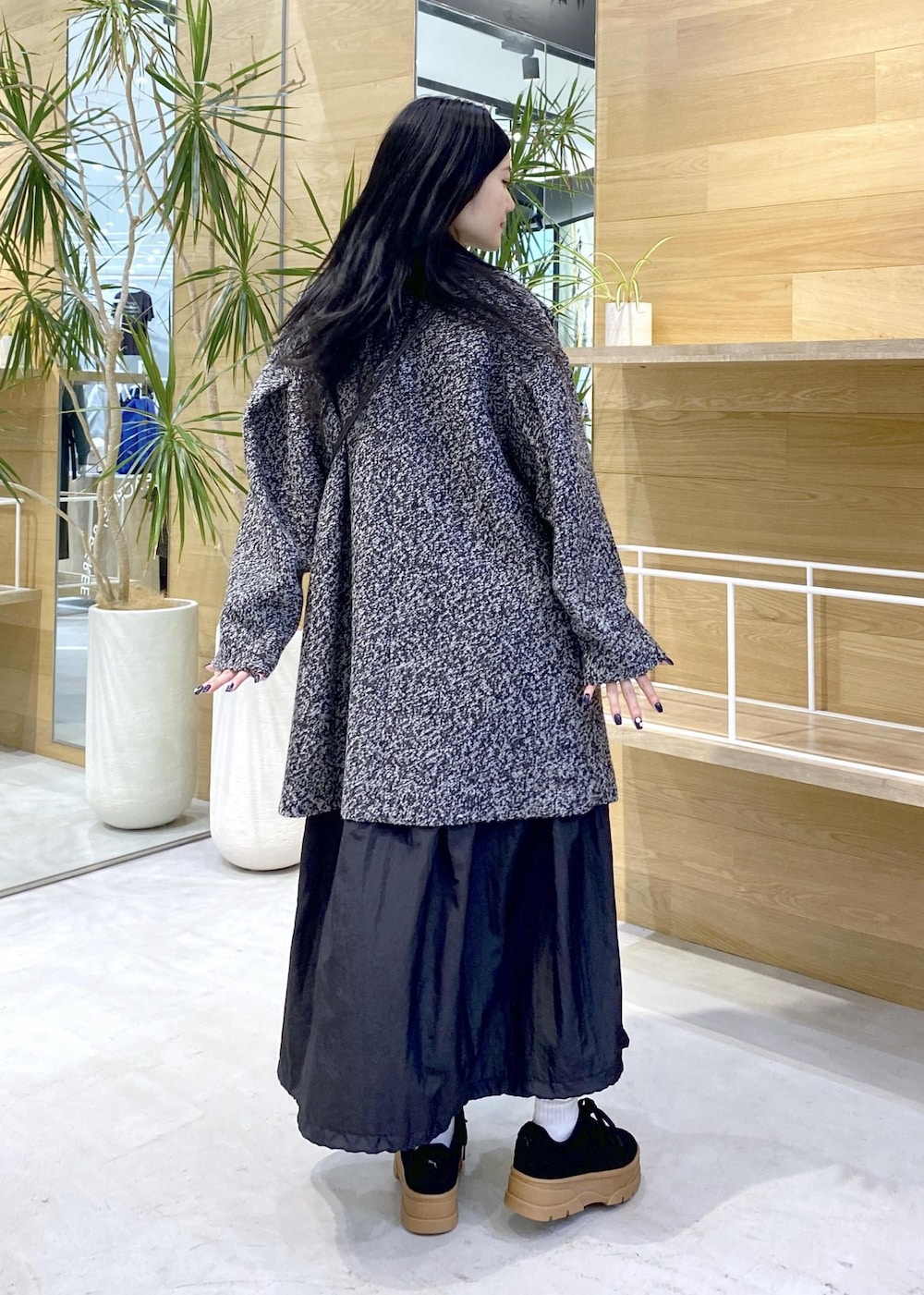 ブラック系のショルダーバッグ、ブラック系のワンピース、ブラック系のチェスターコートを着用したレディースの秋コーディネートの5枚目の写真