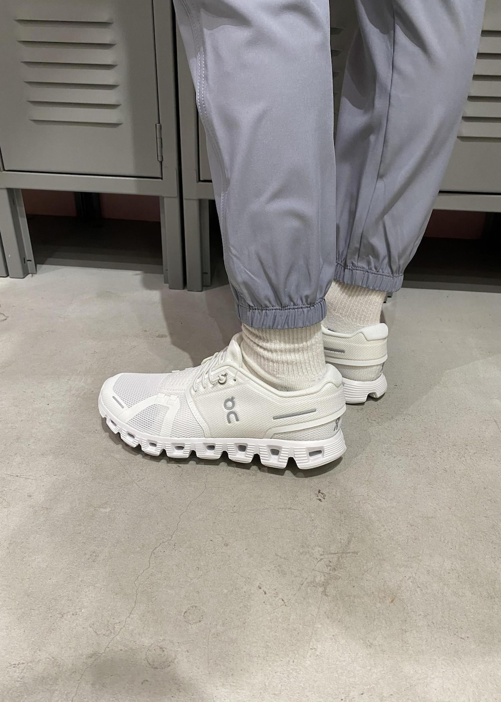 ホワイト系のスニーカー、ブラック系のブルゾン、ホワイト系のブラジャーを着用したレディースの春コーディネートの5枚目の写真