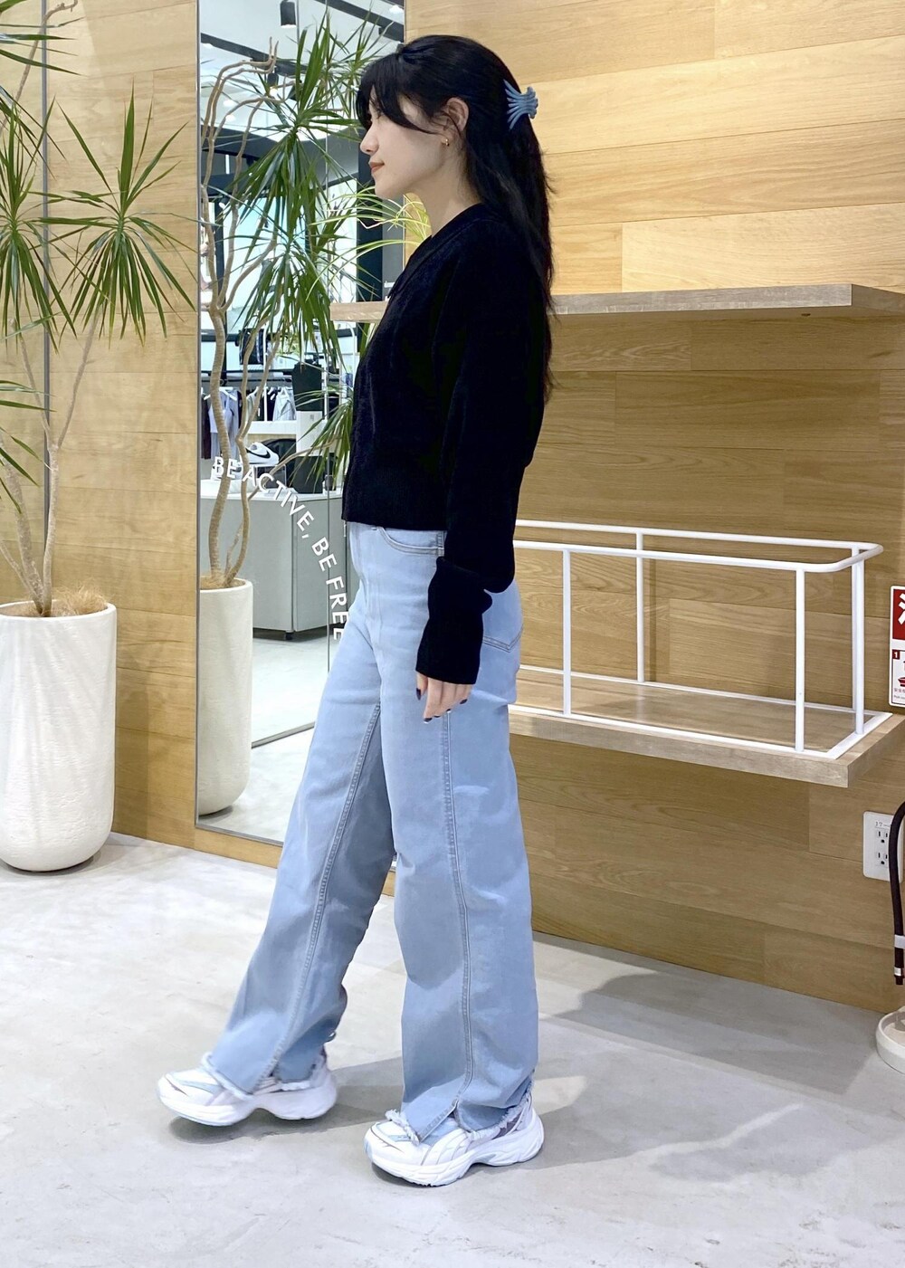 ブルー系のデニムパンツ、ブラック系のショルダーバッグ、ブラック系のカーディガン/ボレロを着用したレディースの秋コーディネートの2枚目の写真