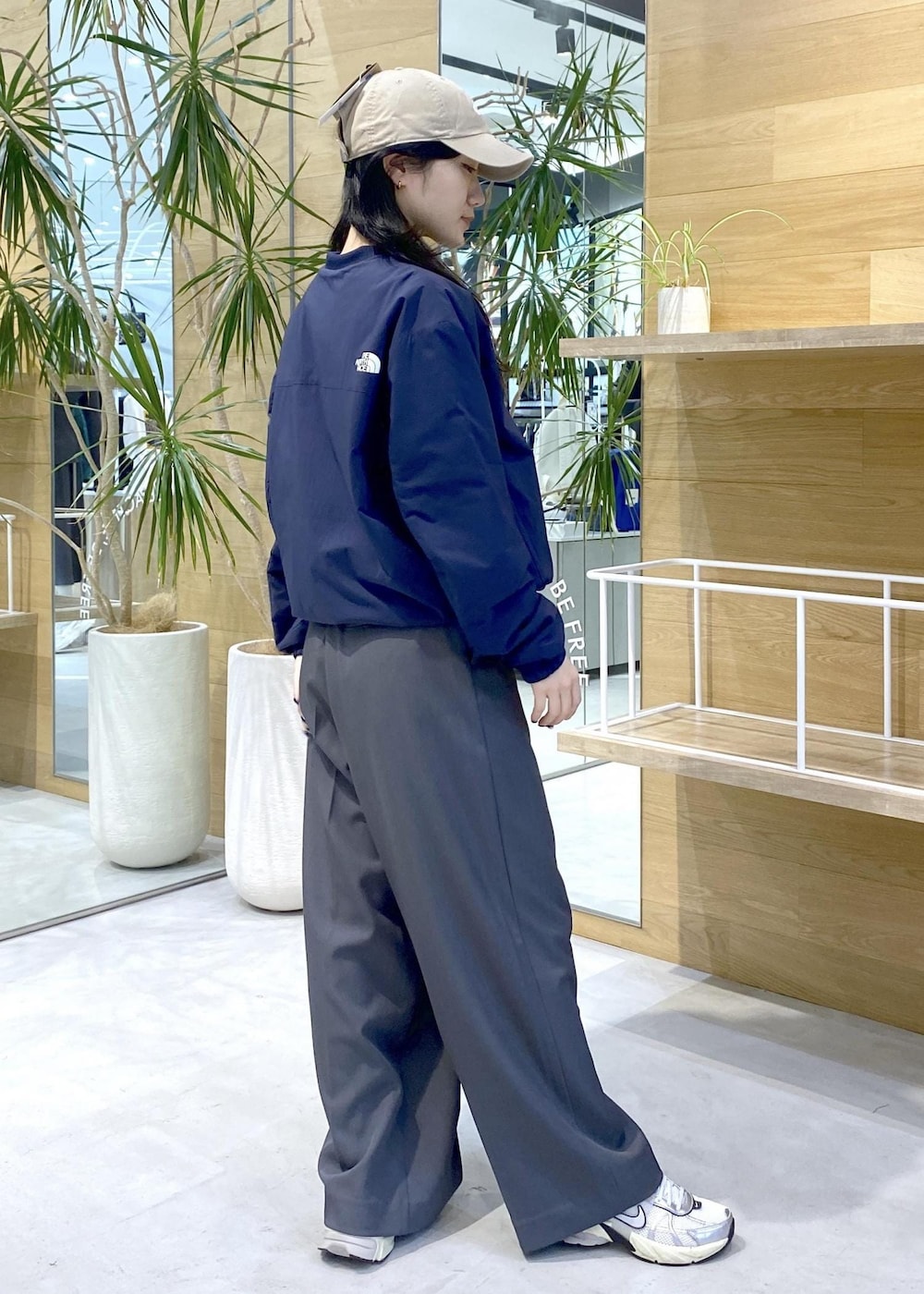 グレー系のスラックス、ホワイト系のスニーカー、ブルー系のその他トップスを着用したレディースの秋コーディネートの4枚目の写真