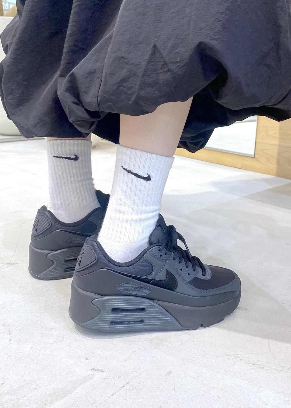 ブラック系のカーディガン/ボレロ、ブラック系のスニーカー、レッド系のスウェットを着用したレディースの冬コーディネートの10枚目の写真