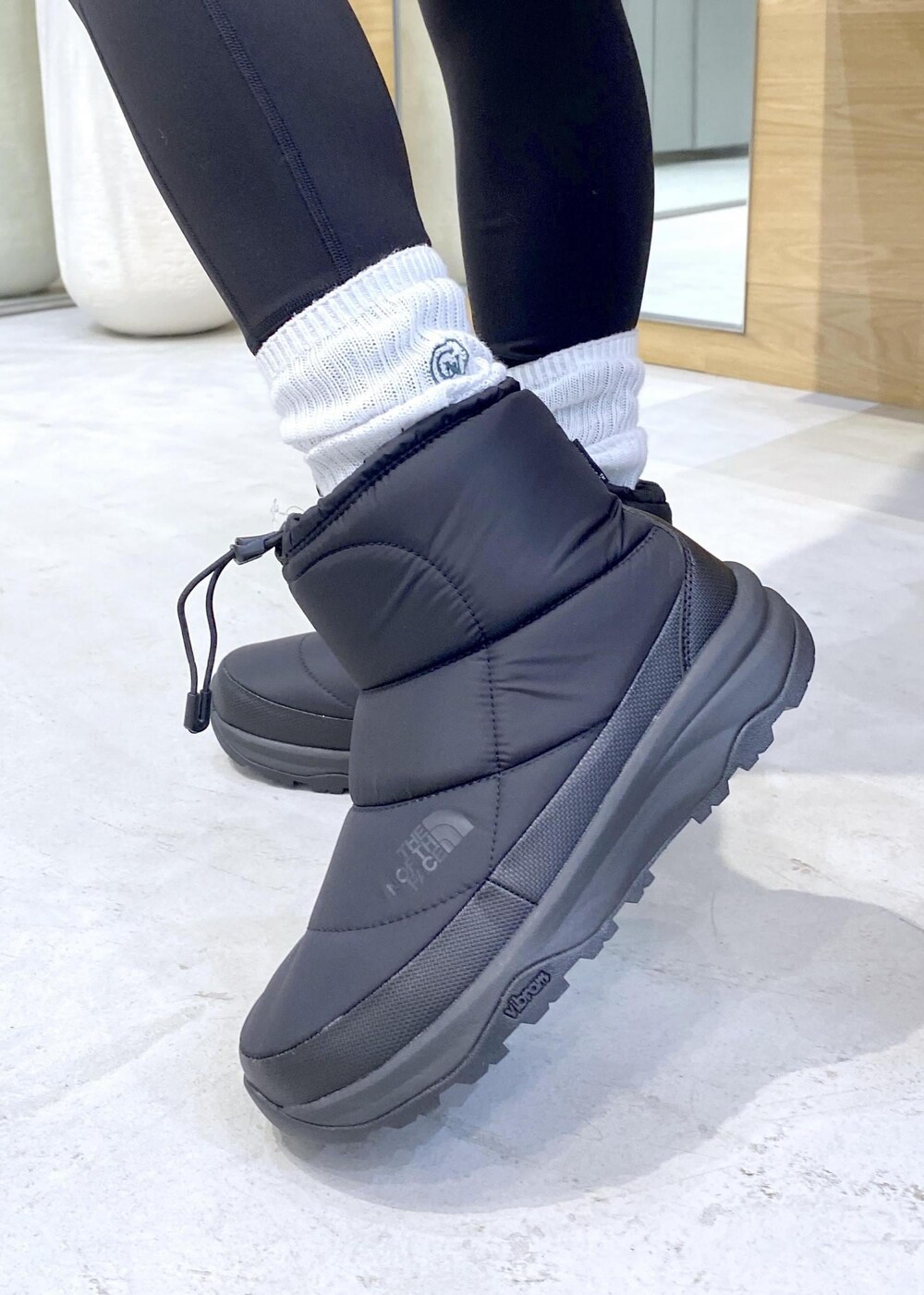 ブラック系のレギンス/スパッツを着用したレディースの秋コーディネートの8枚目の写真