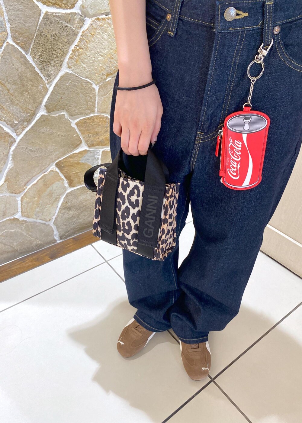 ベージュ系のスニーカー、ブルー系のデニムパンツ、ベージュ系のショルダーバッグを着用したレディースの夏コーディネートの6枚目の写真