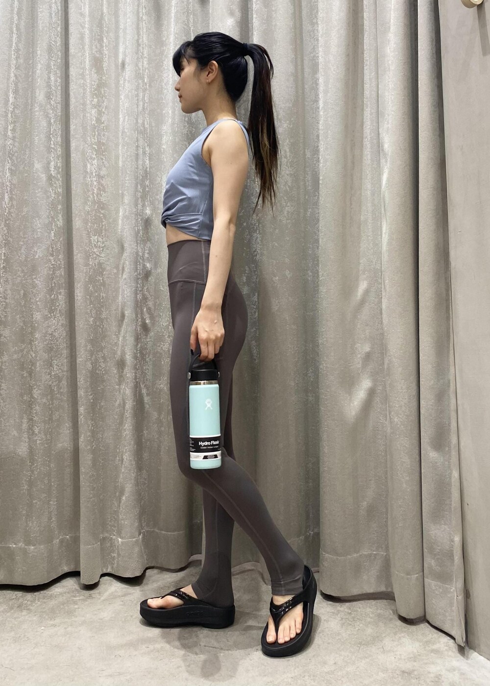 ブラック系のサンダル、ブルー系のタンクトップ、グリーン系のグラス/マグカップ/タンブラーを着用したレディースの春コーディネートの2枚目の写真