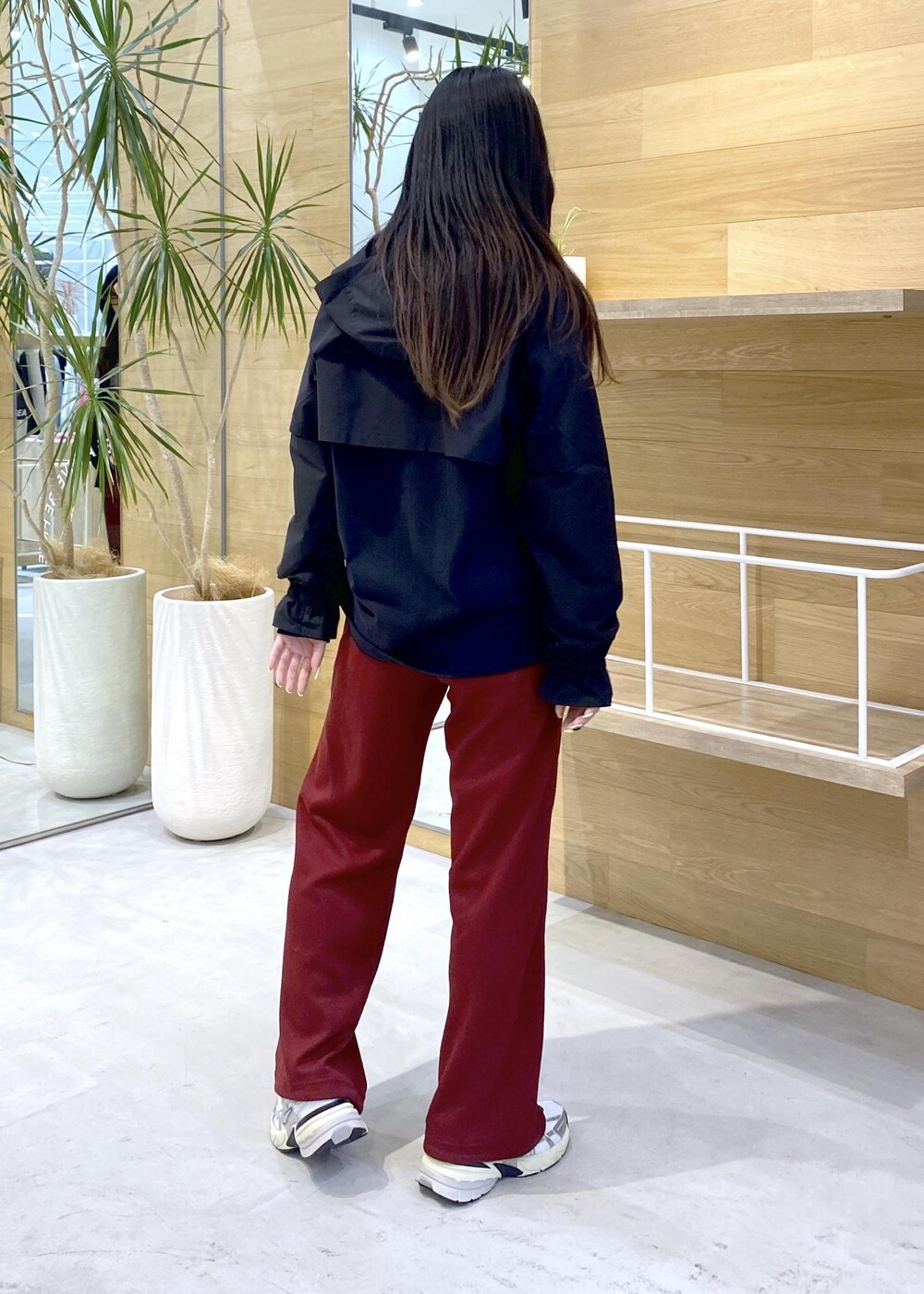グレー系のブルゾン、ホワイト系のスニーカー、レッド系のその他パンツを着用したレディースの秋コーディネートの4枚目の写真