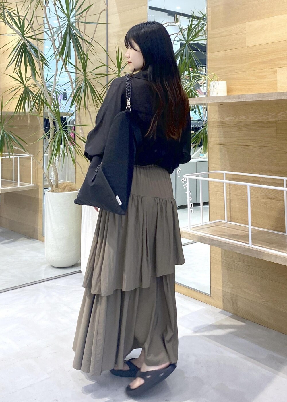 グリーン系のスカート、ブラック系のキャミソール、ブラック系のサンダルを着用したレディースの夏コーディネートの4枚目の写真