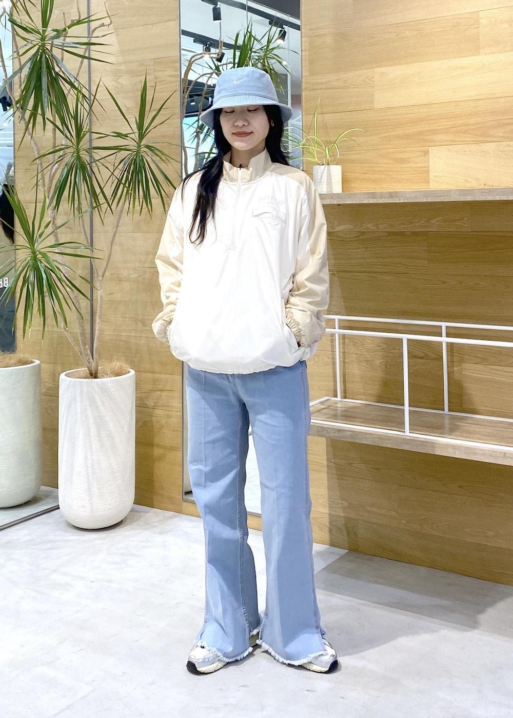 ホワイト系のスニーカー、ブルー系のデニムパンツ、ブルー系のハットを着用したレディースの秋コーディネートの3枚目の写真