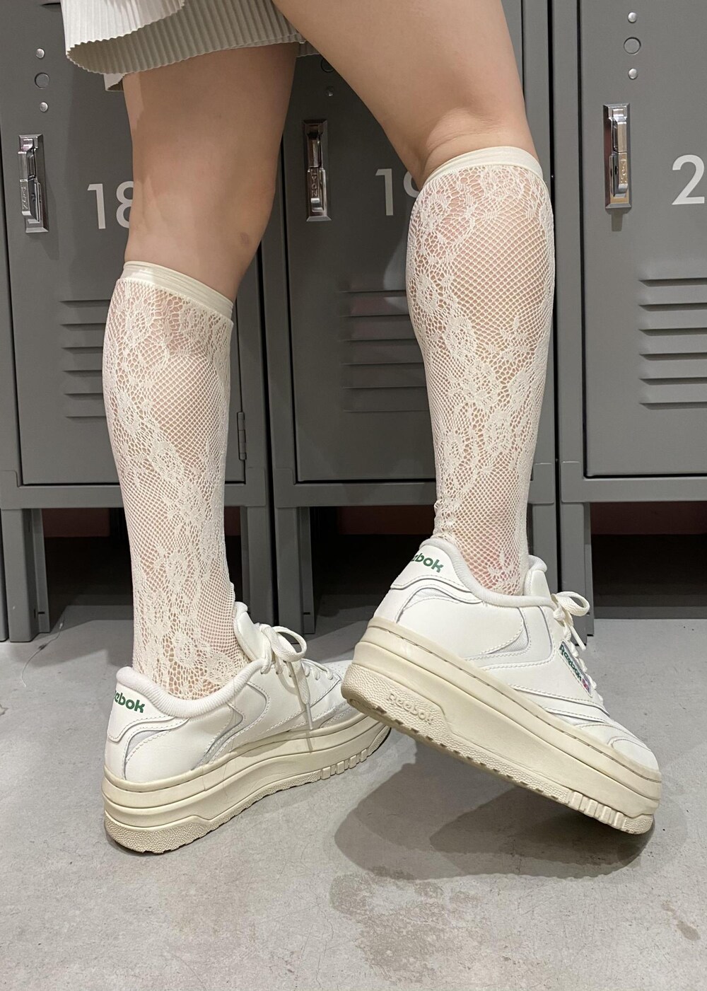 ホワイト系のスニーカー、グレー系のハンドバッグ、ブラック系のパーカーを着用したレディースの春コーディネートの7枚目の写真