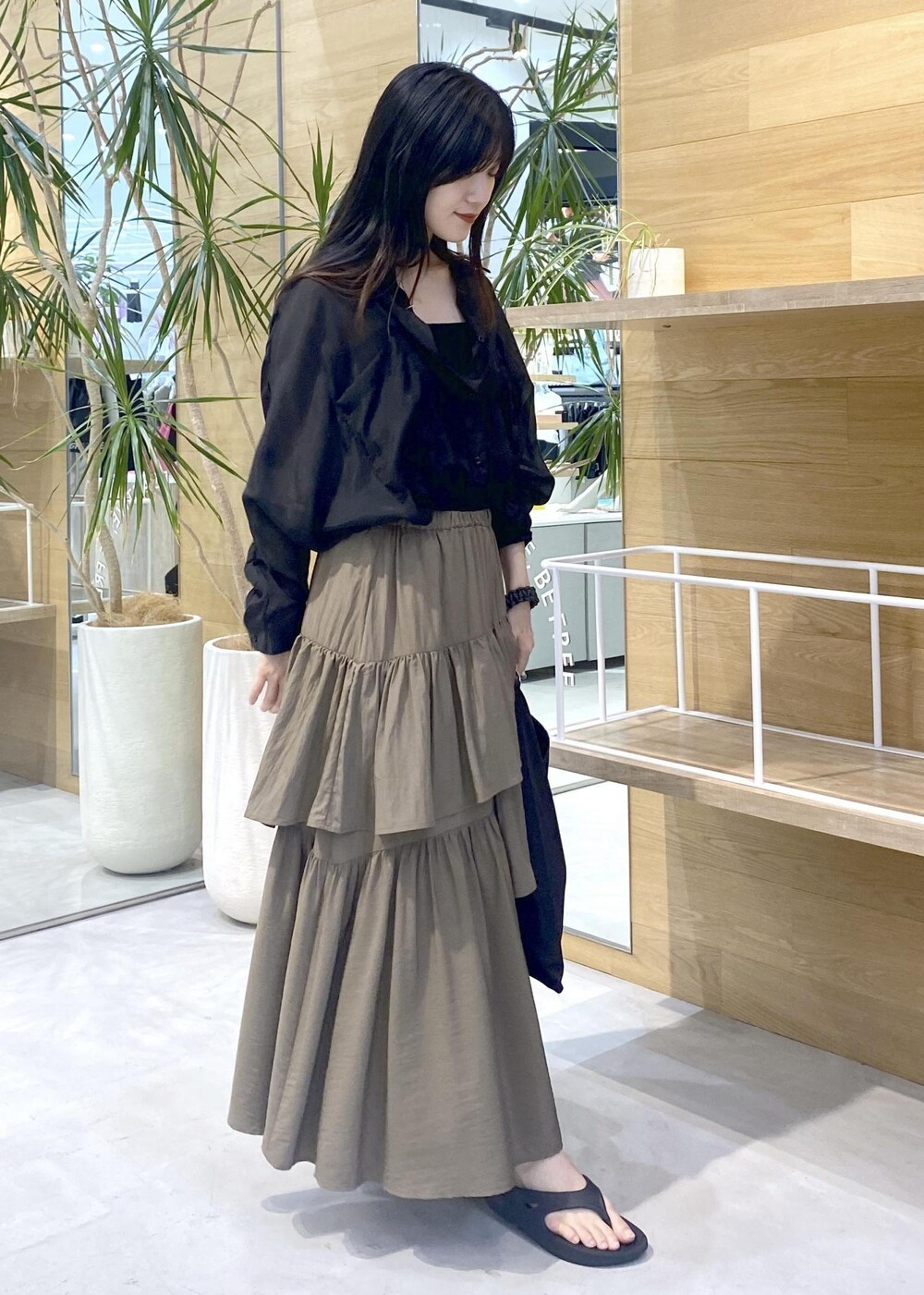 グリーン系のスカート、ブラック系のキャミソール、ブラック系のサンダルを着用したレディースの夏コーディネートの6枚目の写真