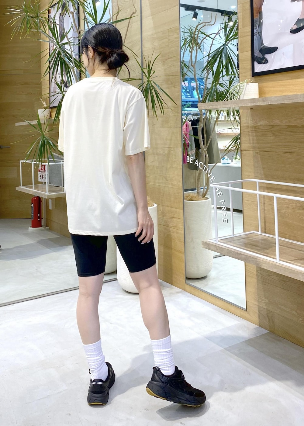 ホワイト系のTシャツ/カットソー、ブラック系のスニーカー、ブラック系のレギンス/スパッツを着用したレディースの夏コーディネートの3枚目の写真