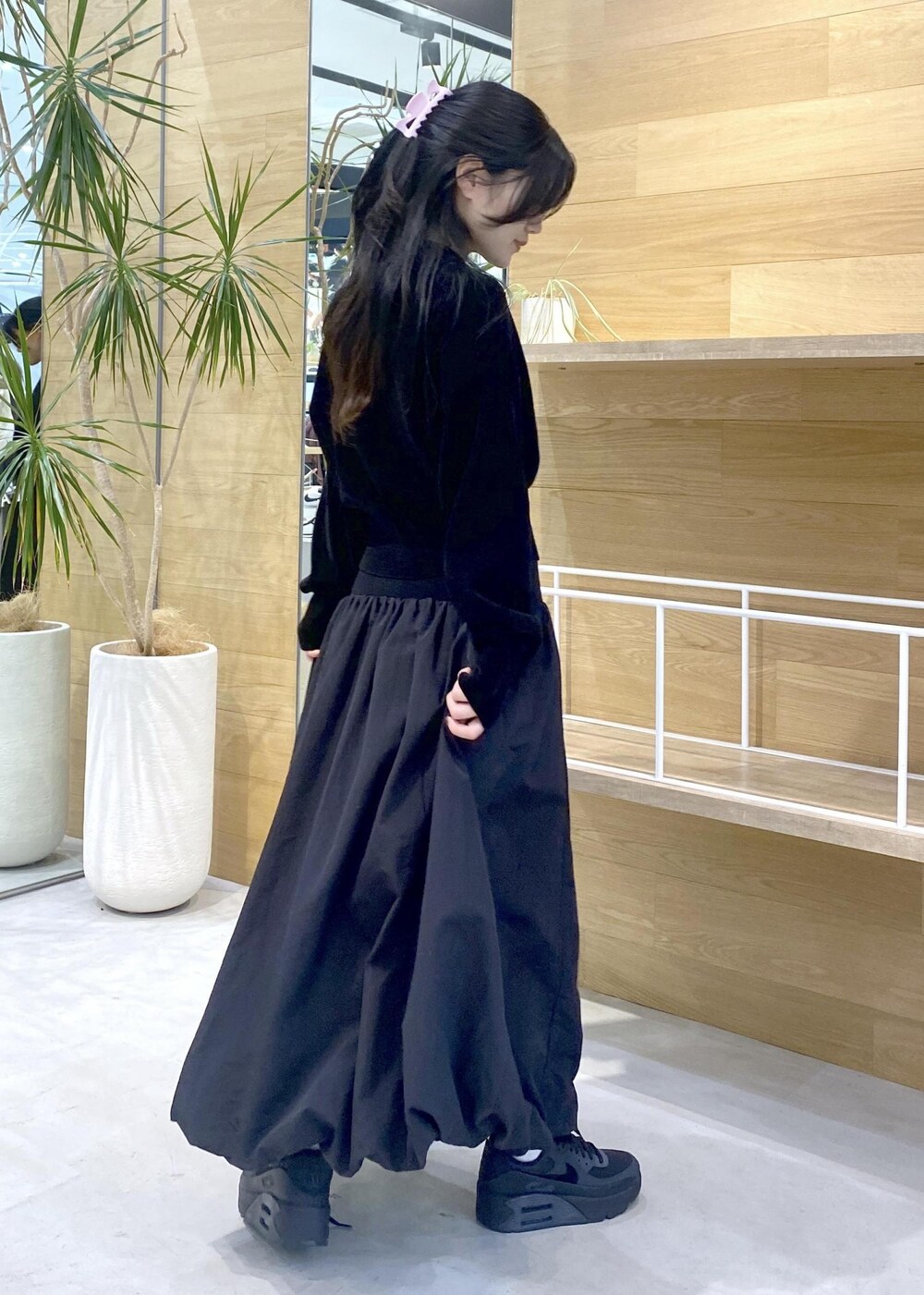 ブラック系のスカート、ブラック系のカーディガン/ボレロ、ブラック系のスニーカーを着用したレディースの冬コーディネートの5枚目の写真