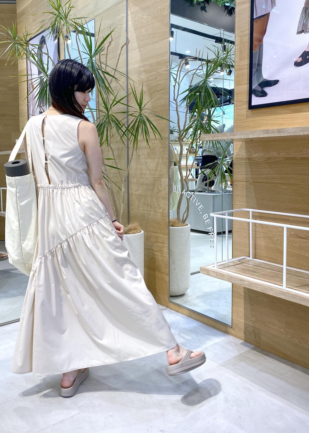 ベージュ系のサンダル、ホワイト系のトートバッグ、ホワイト系のワンピースを着用したレディースの夏コーディネートの4枚目の写真