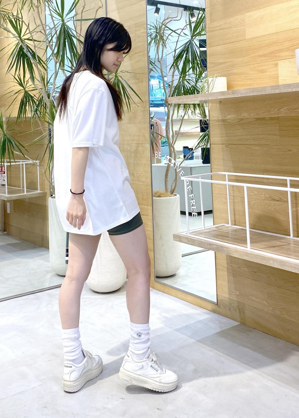 ホワイト系のスニーカー、ホワイト系のTシャツ/カットソー、グリーン系のレギンス/スパッツを着用したレディースの夏コーディネートの4枚目の写真