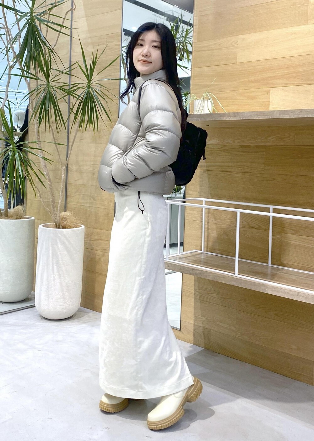 ベージュ系のダウンジャケット/コート、ホワイト系のブーツ、ホワイト系のスカートを着用したレディースの冬コーディネートの7枚目の写真