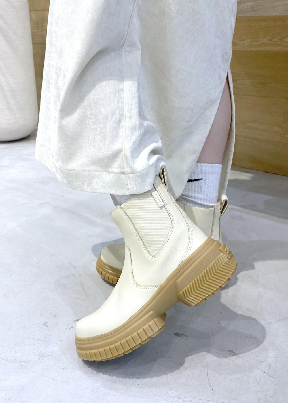 ホワイト系のショルダーバッグ、ホワイト系のブーツ、ホワイト系のパーカーを着用したレディースの冬コーディネートの8枚目の写真