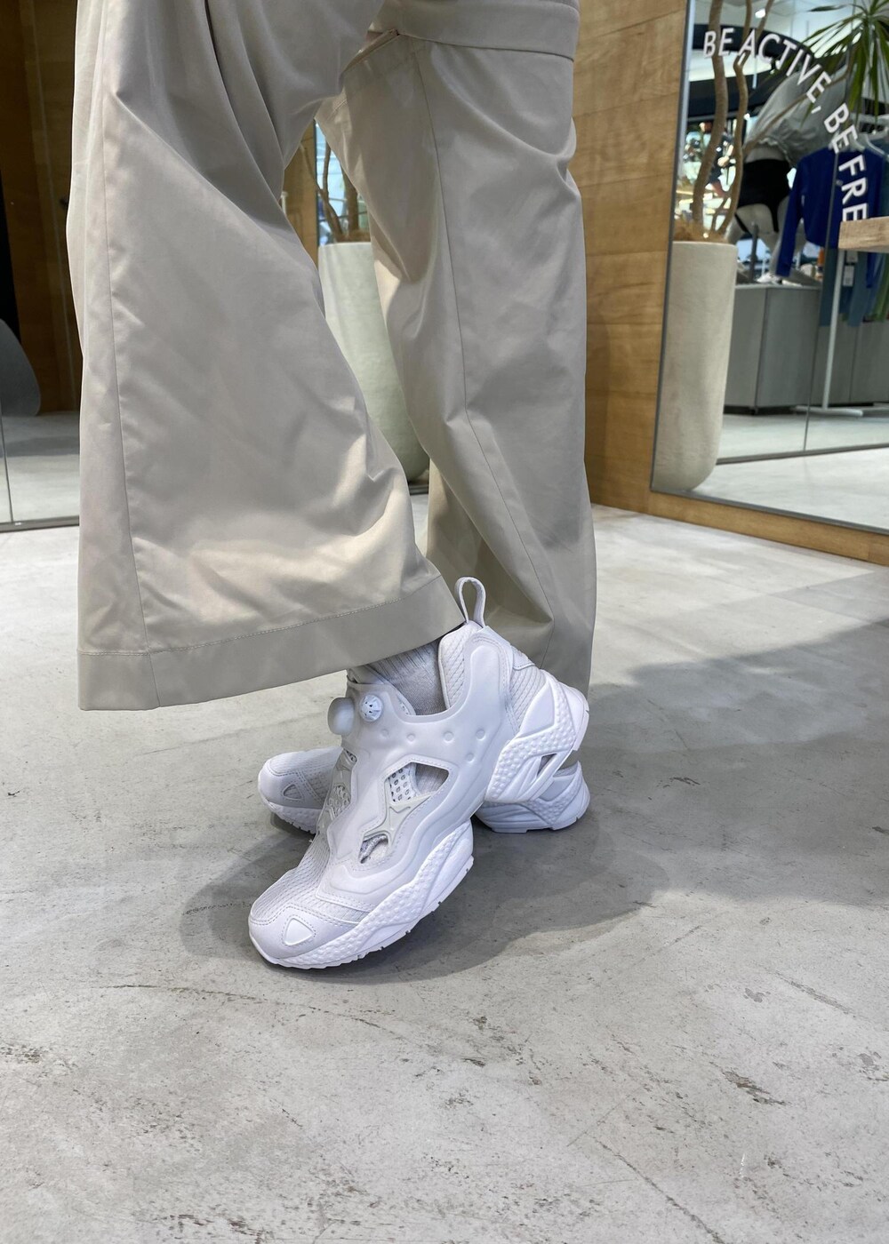 ブラック系のカーゴパンツ、ホワイト系のスニーカー、ホワイト系のタンクトップを着用したレディースの春コーディネートの7枚目の写真