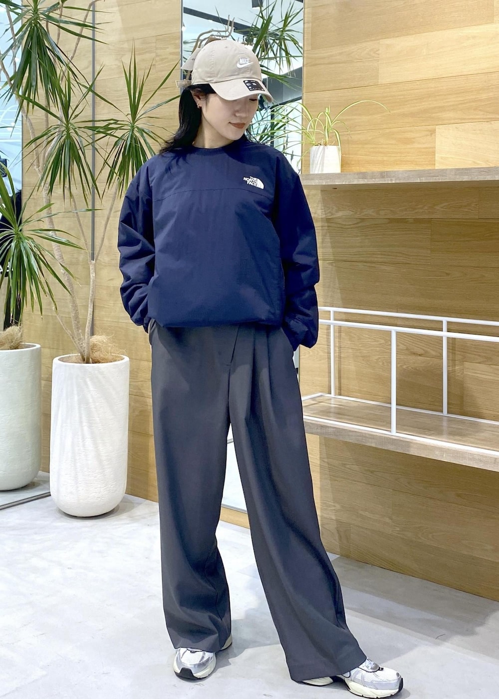 グレー系のスラックス、ホワイト系のスニーカー、ブルー系のその他トップスを着用したレディースの秋コーディネートの7枚目の写真