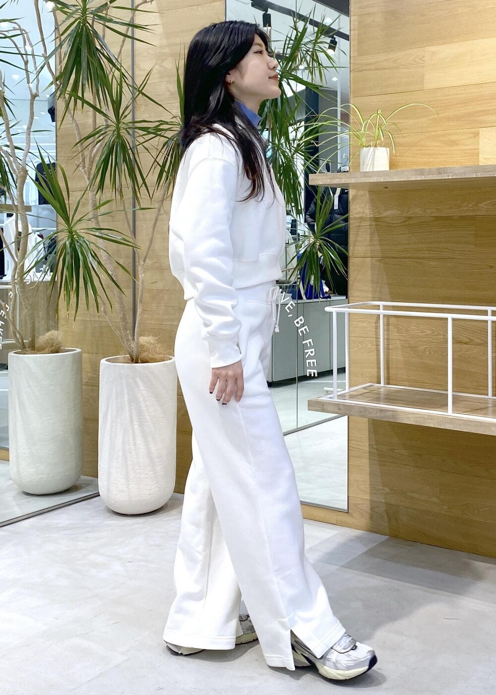 ホワイト系のスニーカー、ブルー系のニット/セーター、ブラック系のその他パンツを着用したレディースの秋コーディネートの5枚目の写真