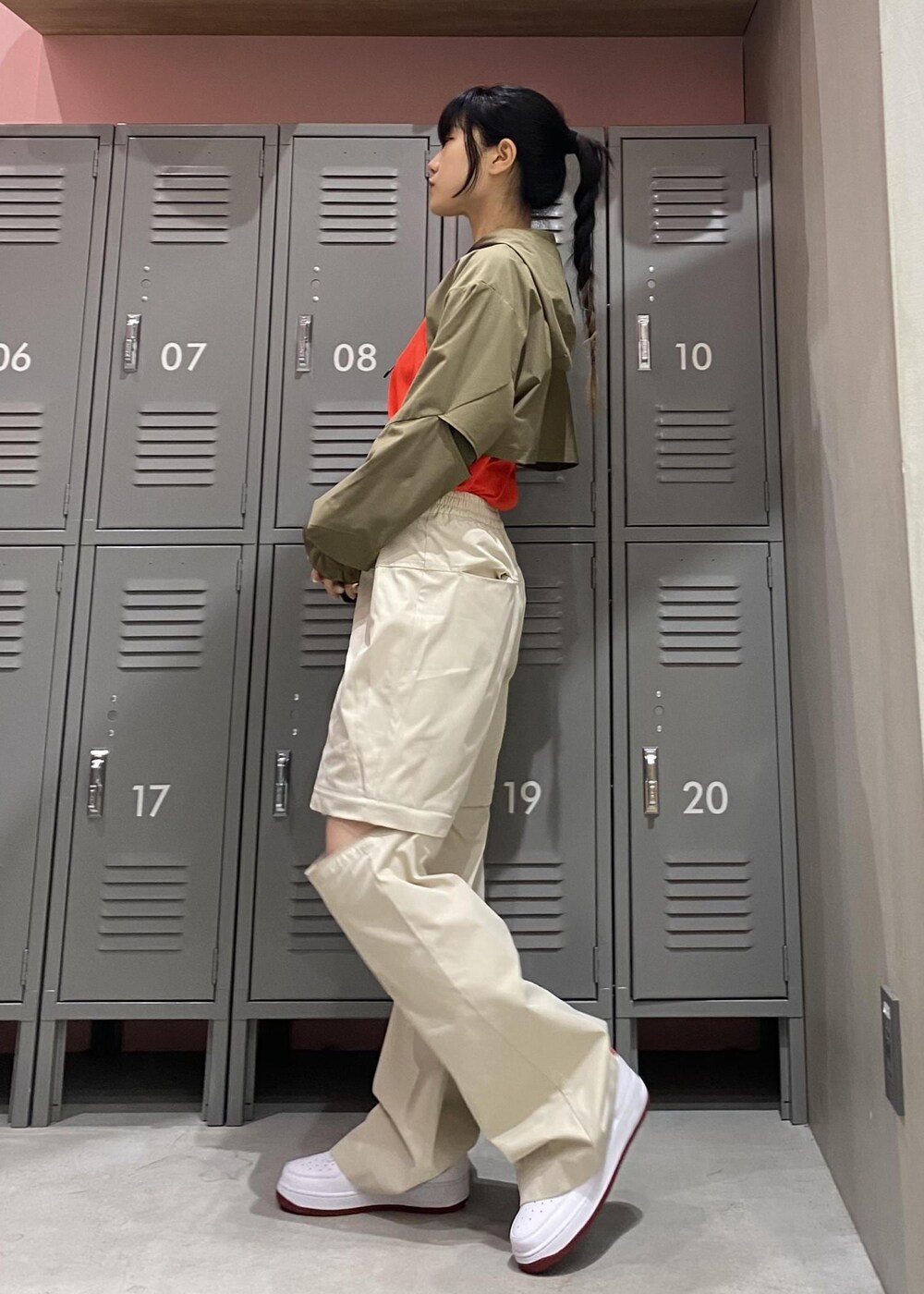 ホワイト系のスニーカー、レッド系のタンクトップ、グレー系のその他パンツを着用したレディースの冬コーディネートの3枚目の写真