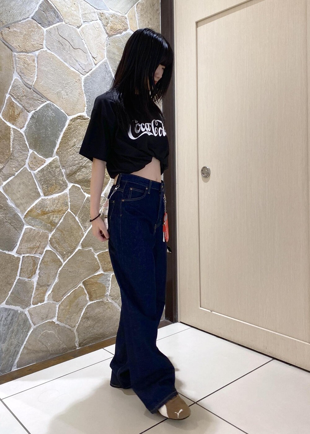 ベージュ系のスニーカー、ブルー系のデニムパンツ、ベージュ系のショルダーバッグを着用したレディースの夏コーディネートの3枚目の写真