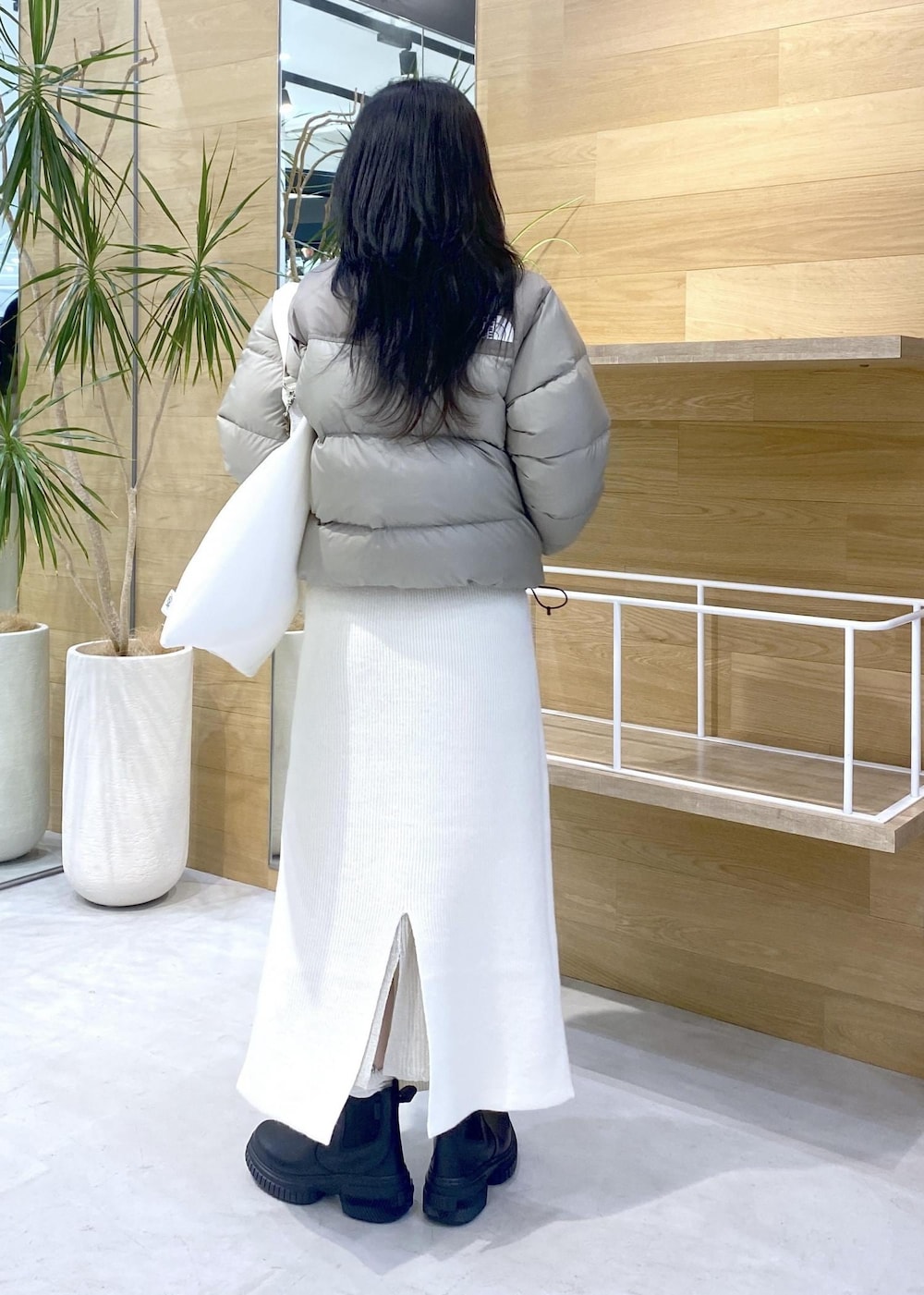 ホワイト系のトートバッグ、ベージュ系のダウンジャケット/コートを着用したレディースの秋コーディネートの6枚目の写真