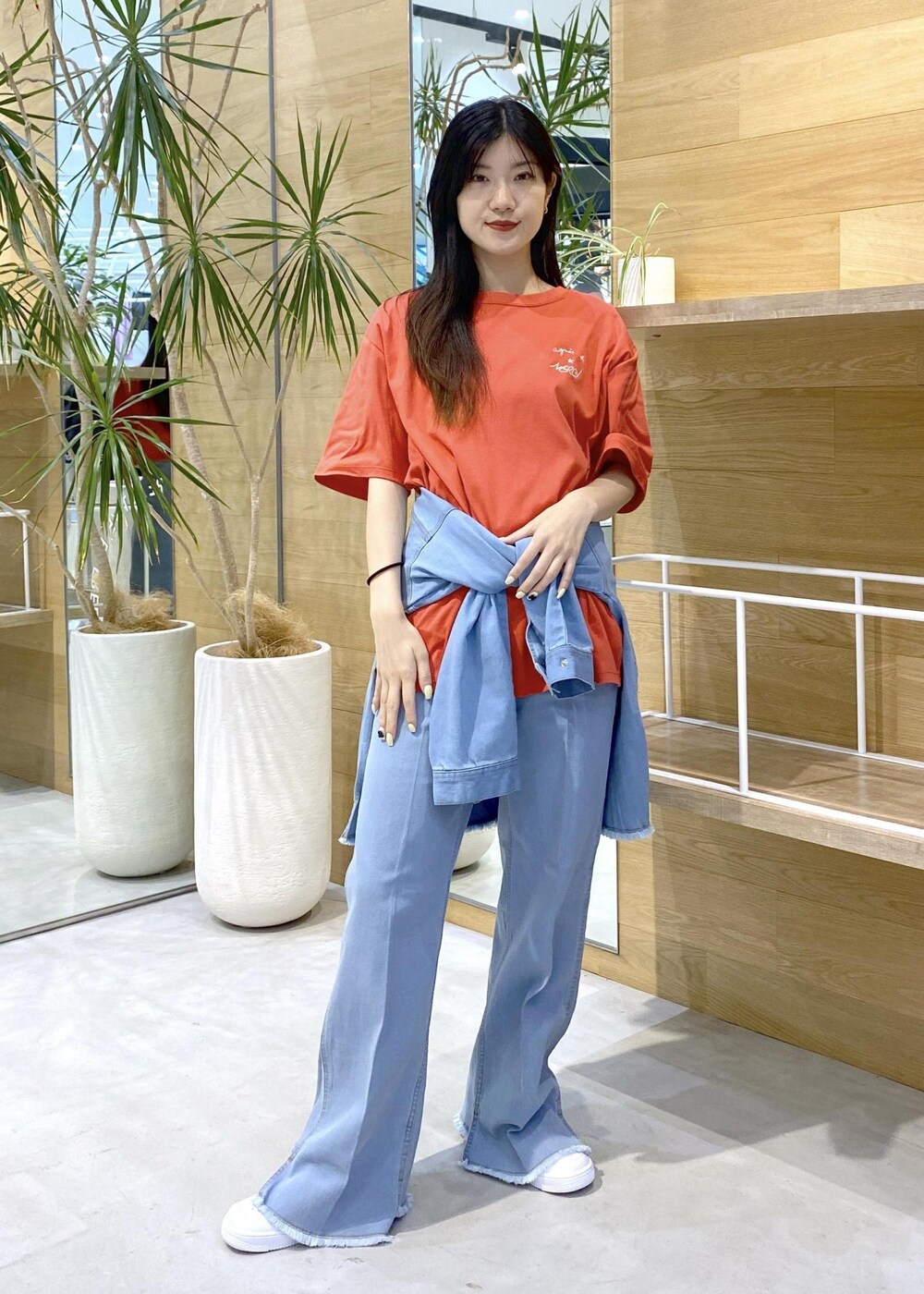 ホワイト系のスニーカー、ブルー系のパーカー、ブルー系のデニムパンツを着用したレディースの秋コーディネートの2枚目の写真