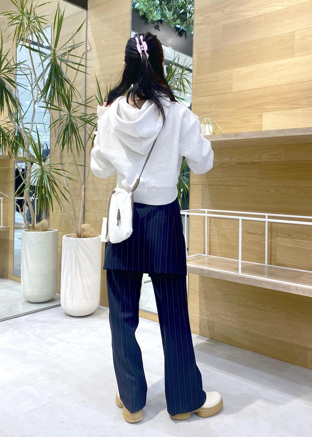 ホワイト系のショルダーバッグ、ホワイト系のブーツ、ホワイト系のパーカーを着用したレディースの冬コーディネートの4枚目の写真