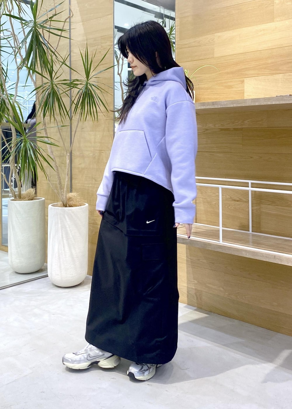 ホワイト系のスニーカー、パープル系のパーカー、ブラック系のスカートを着用したレディースの秋コーディネートの3枚目の写真