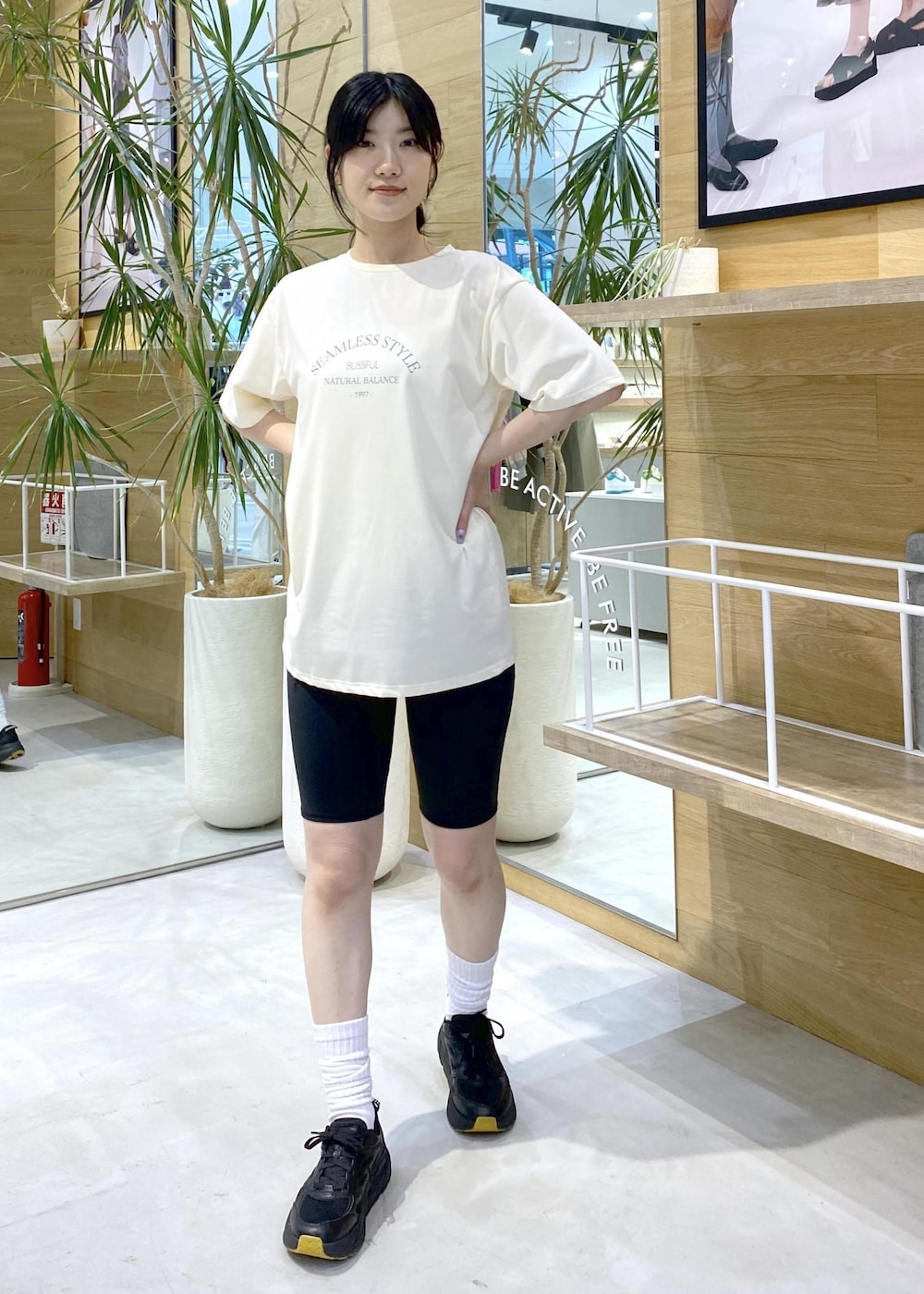 ホワイト系のTシャツ/カットソー、ブラック系のスニーカー、ブラック系のレギンス/スパッツを着用したレディースの夏コーディネートの2枚目の写真