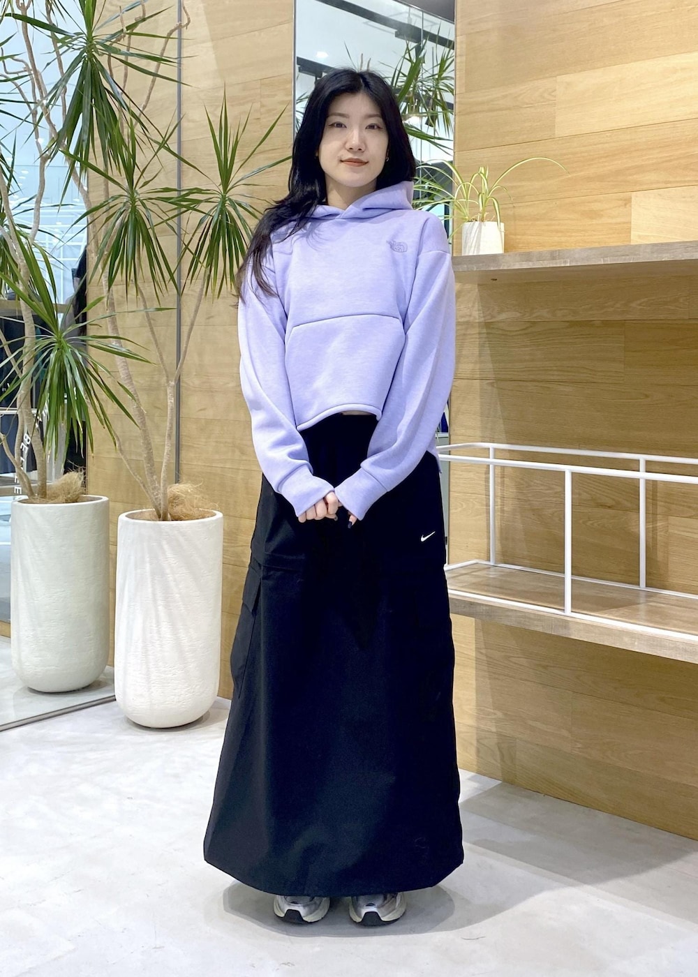 ホワイト系のスニーカー、パープル系のパーカー、ブラック系のスカートを着用したレディースの秋コーディネートの6枚目の写真