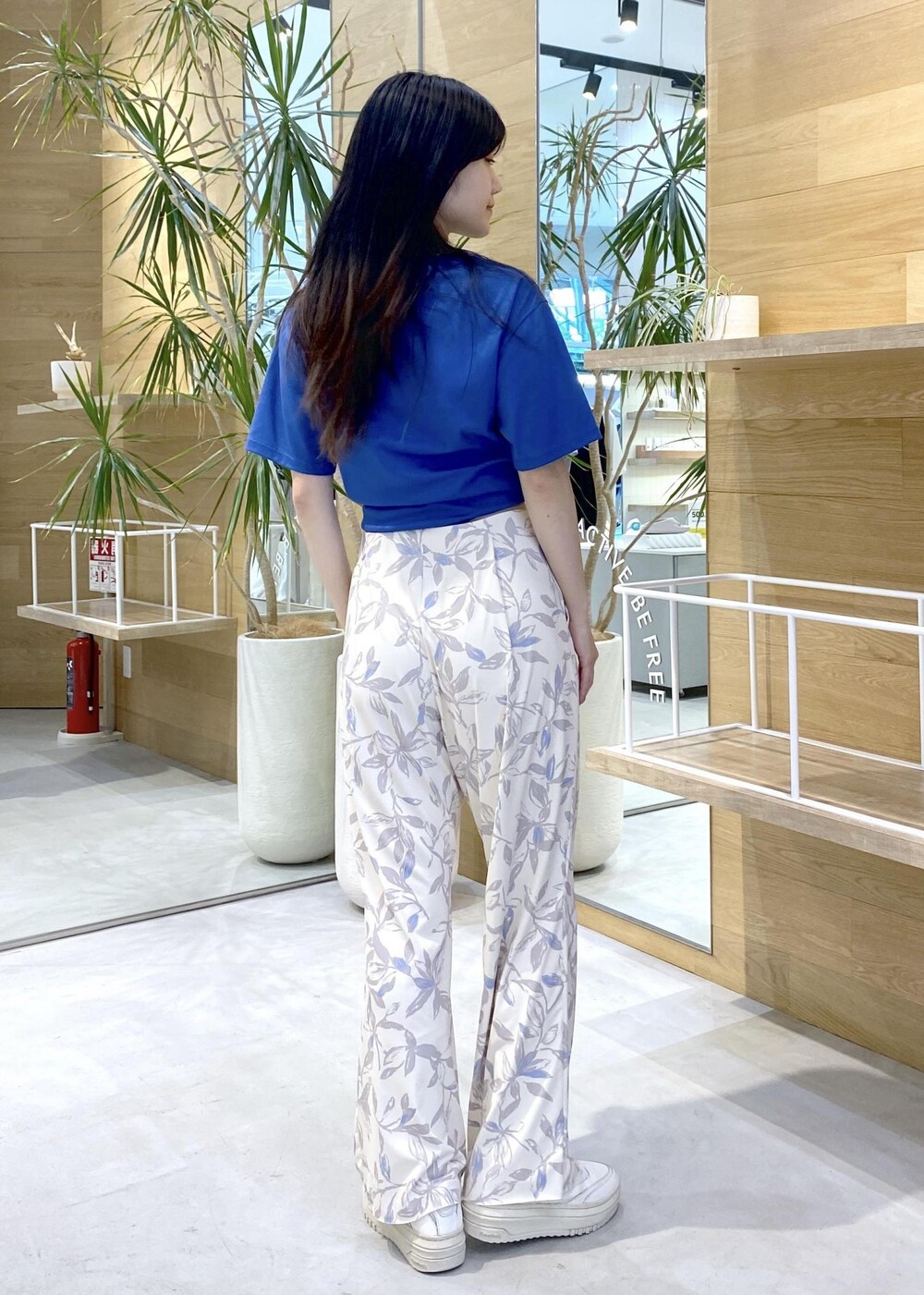 ベージュ系のその他パンツ、ホワイト系のスニーカー、ブルー系のTシャツ/カットソーを着用したレディースの夏コーディネートの4枚目の写真