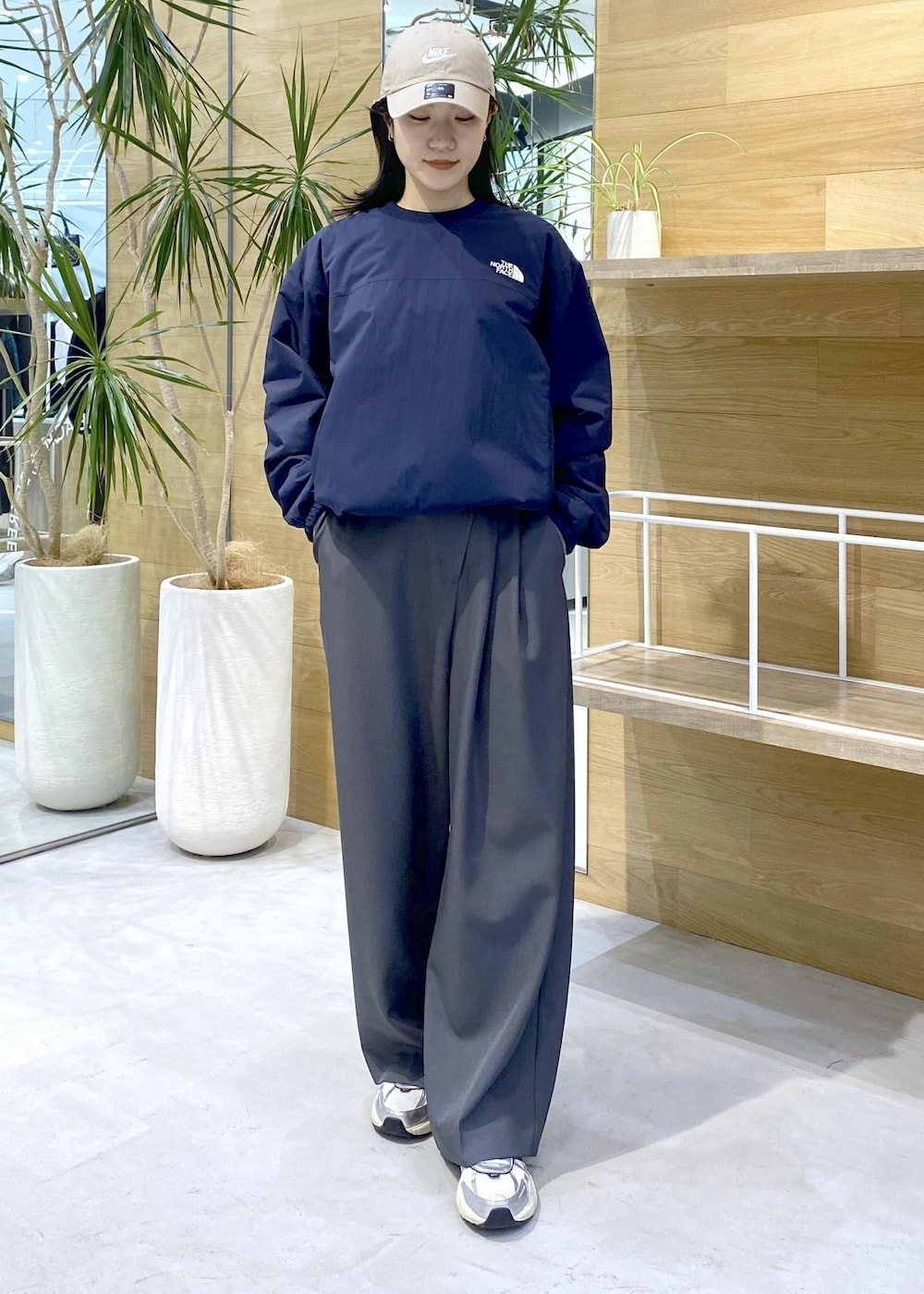 グレー系のスラックス、ホワイト系のスニーカー、ブルー系のその他トップスを着用したレディースの秋コーディネートの6枚目の写真