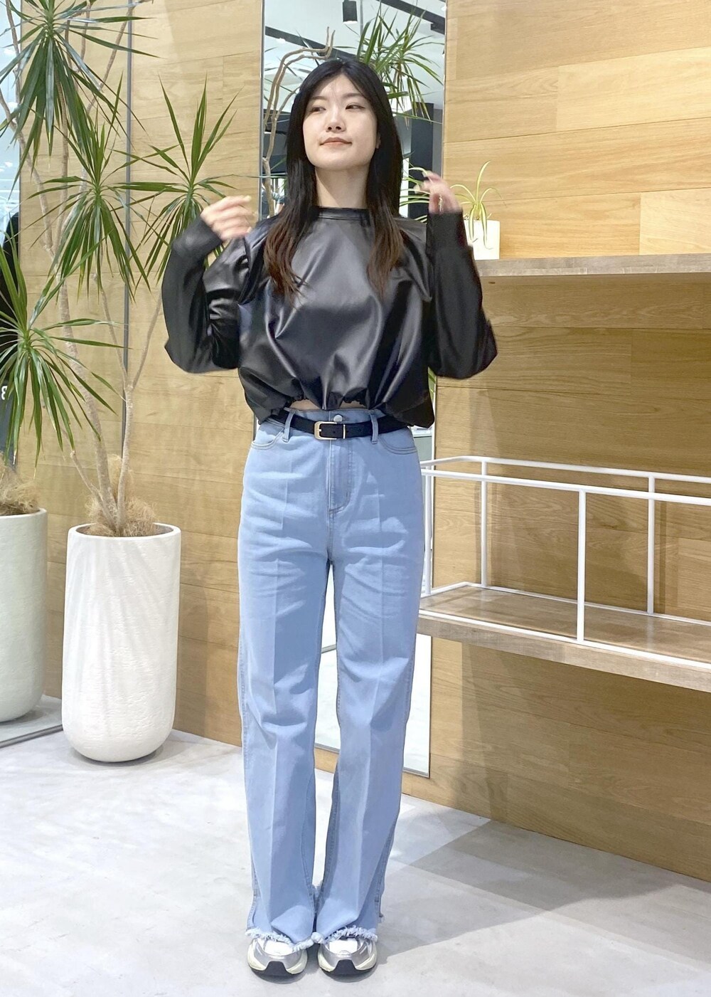 ブラック系のその他トップス、ブルー系のデニムパンツ、ホワイト系のスニーカーを着用したレディースの秋コーディネートの3枚目の写真