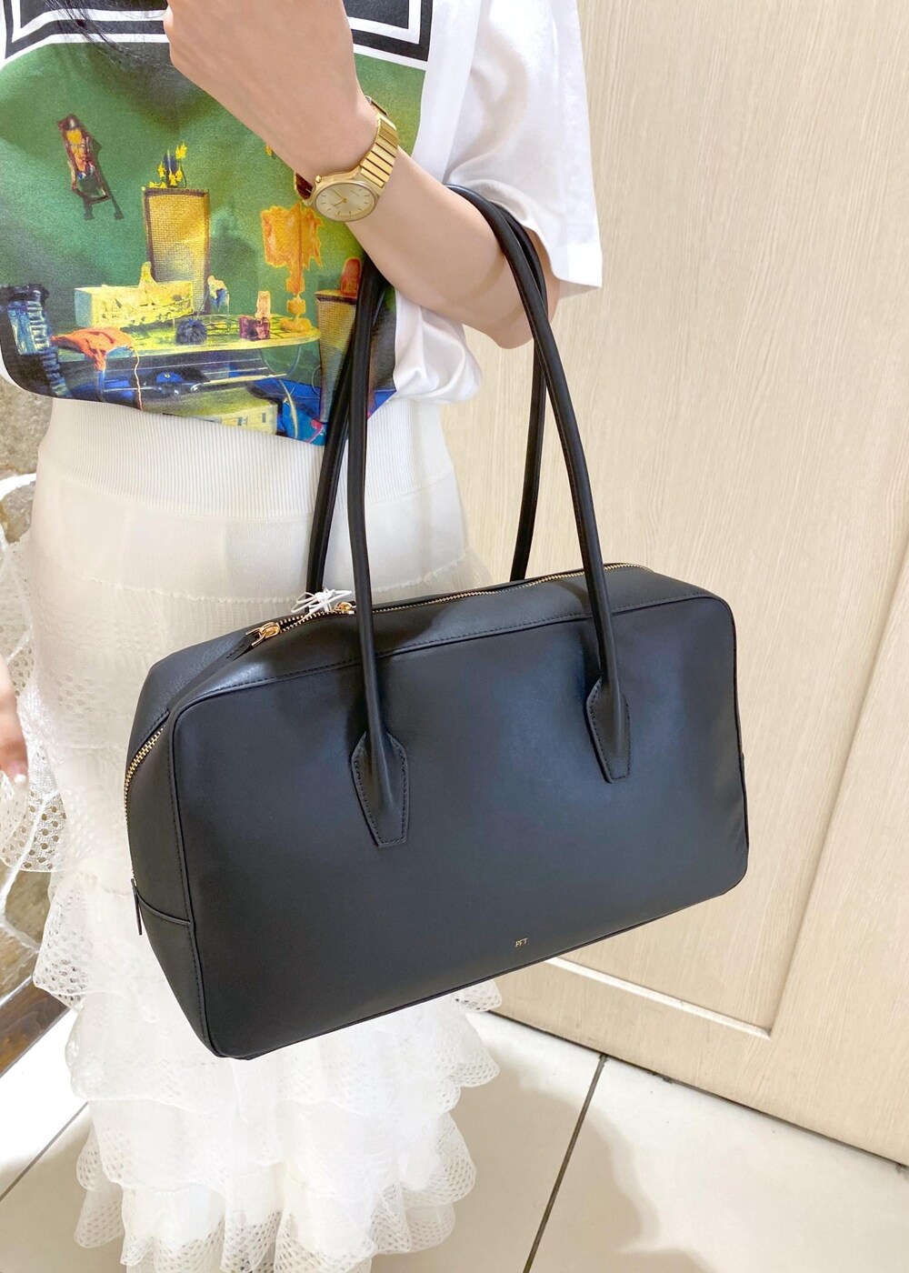 グリーン系のサンダル、ホワイト系のスカート、ブラック系のボストンバッグを着用したレディースの夏コーディネートの8枚目の写真