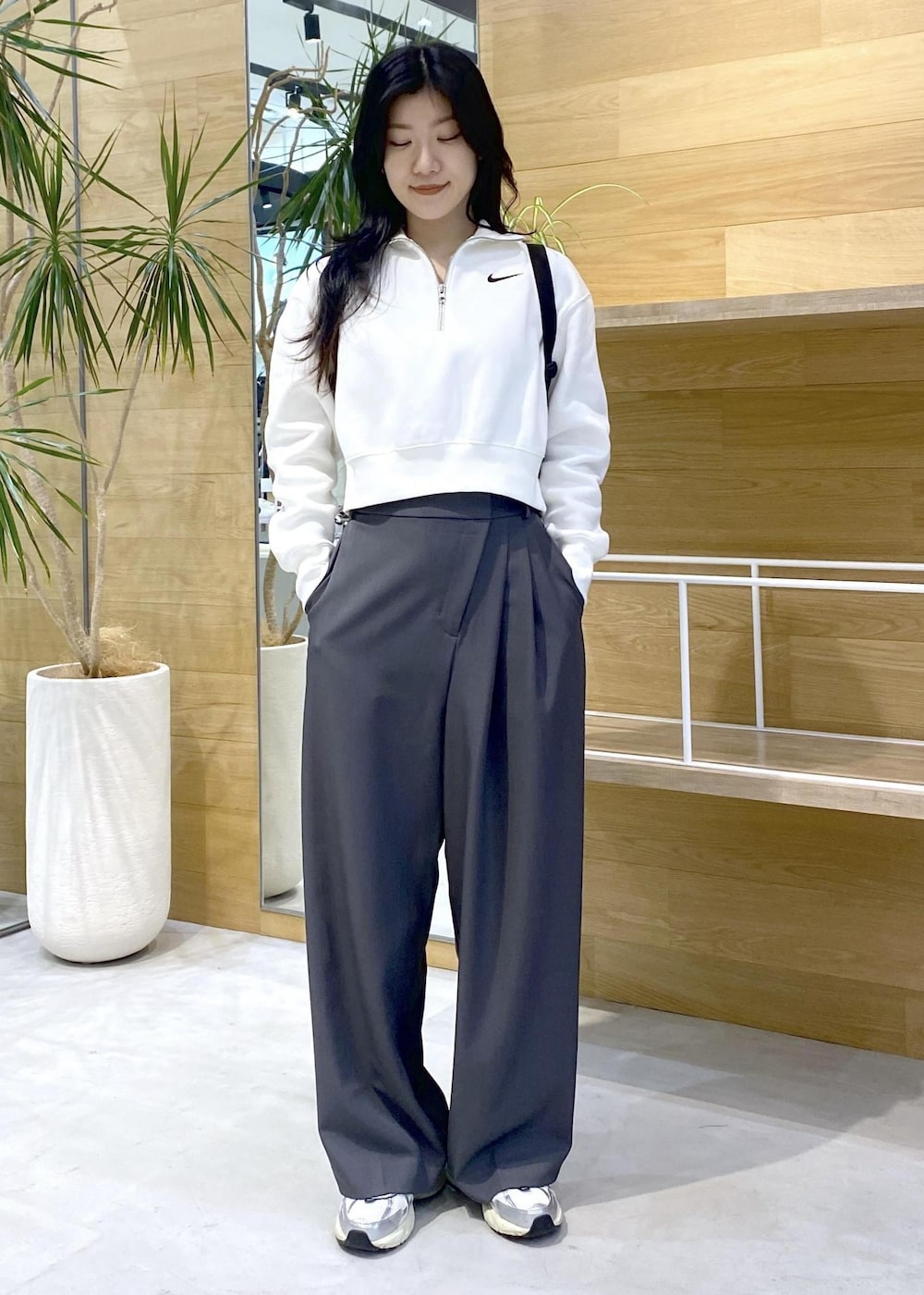 グレー系のスラックス、ホワイト系のスニーカーを着用したレディースの秋コーディネートの6枚目の写真