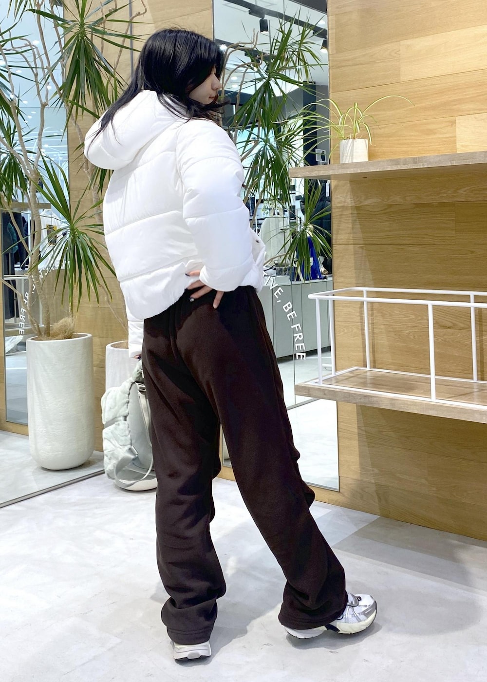 ブラウン系のその他パンツ、ホワイト系のスニーカー、ホワイト系のダウンジャケット/コートを着用したレディースの秋コーディネートの5枚目の写真