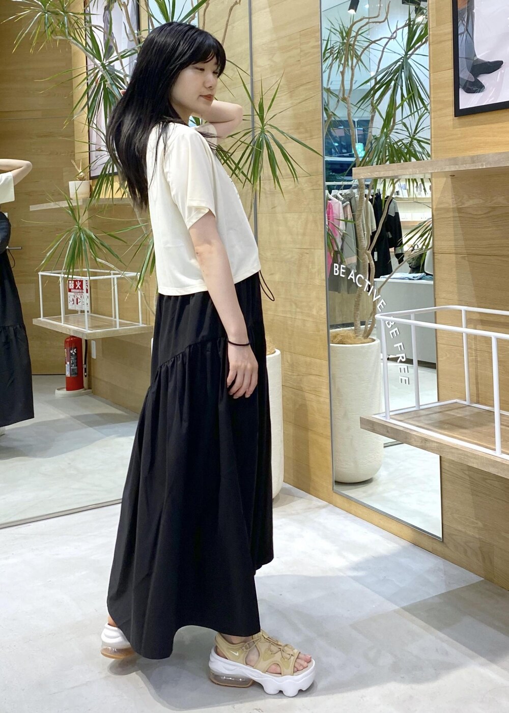 ベージュ系のサンダル、ホワイト系のTシャツ/カットソー、ブラック系のボディバッグ/ウエストポーチを着用したレディースの夏コーディネートの2枚目の写真