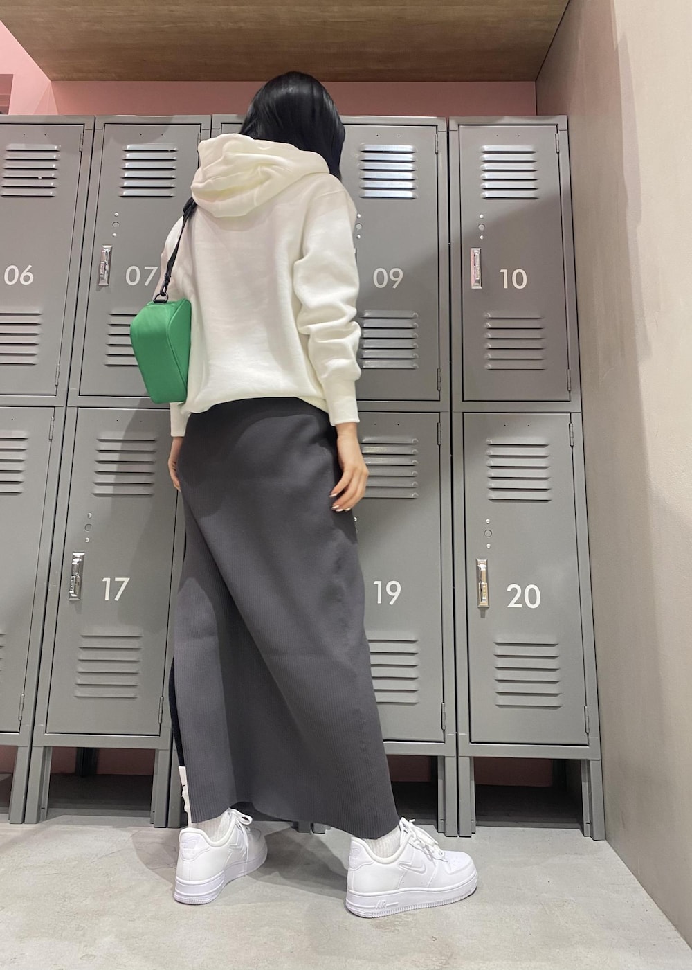 ホワイト系のパーカー、ホワイト系のスニーカー、ブラック系のワンピースを着用したレディースの冬コーディネートの3枚目の写真