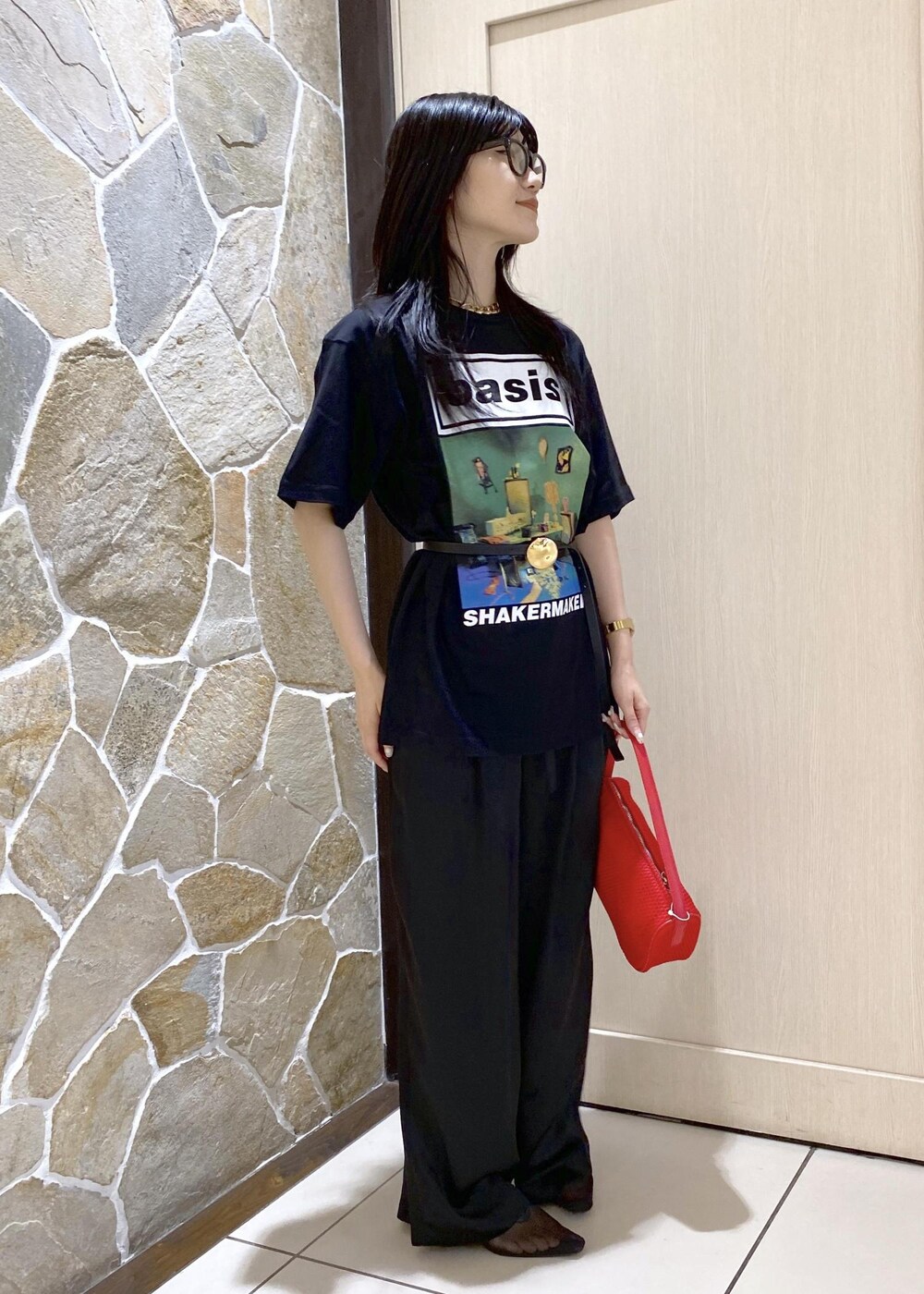 ブラック系のパンプス、ブラック系のスラックス、レッド系のハンドバッグを着用したレディースの夏コーディネートの4枚目の写真