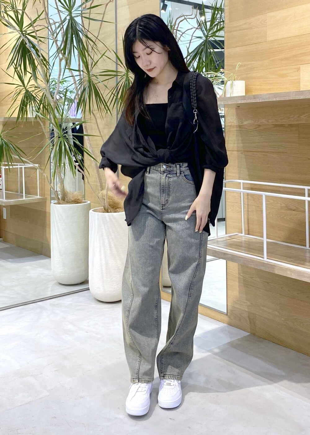 ホワイト系のスニーカー、ブラック系のキャミソール、ベージュ系のデニムパンツを着用したレディースの秋コーディネートの7枚目の写真