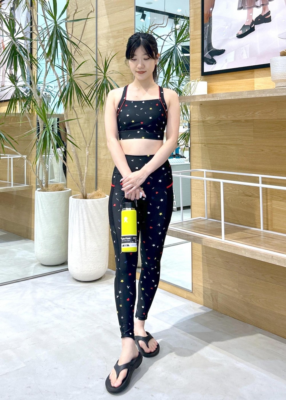 ブラック系のサンダル、イエロー系のグラス/マグカップ/タンブラー、ブラック系のレギンス/スパッツを着用したレディースの夏コーディネートの2枚目の写真