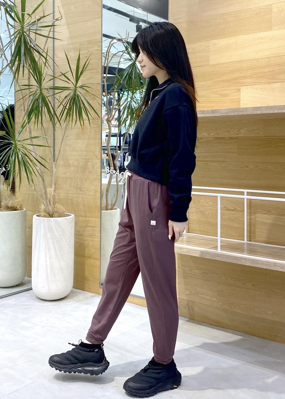 ピンク系のスラックス、ブラック系のスニーカー、ブラック系のスウェットを着用したレディースの秋コーディネートの5枚目の写真