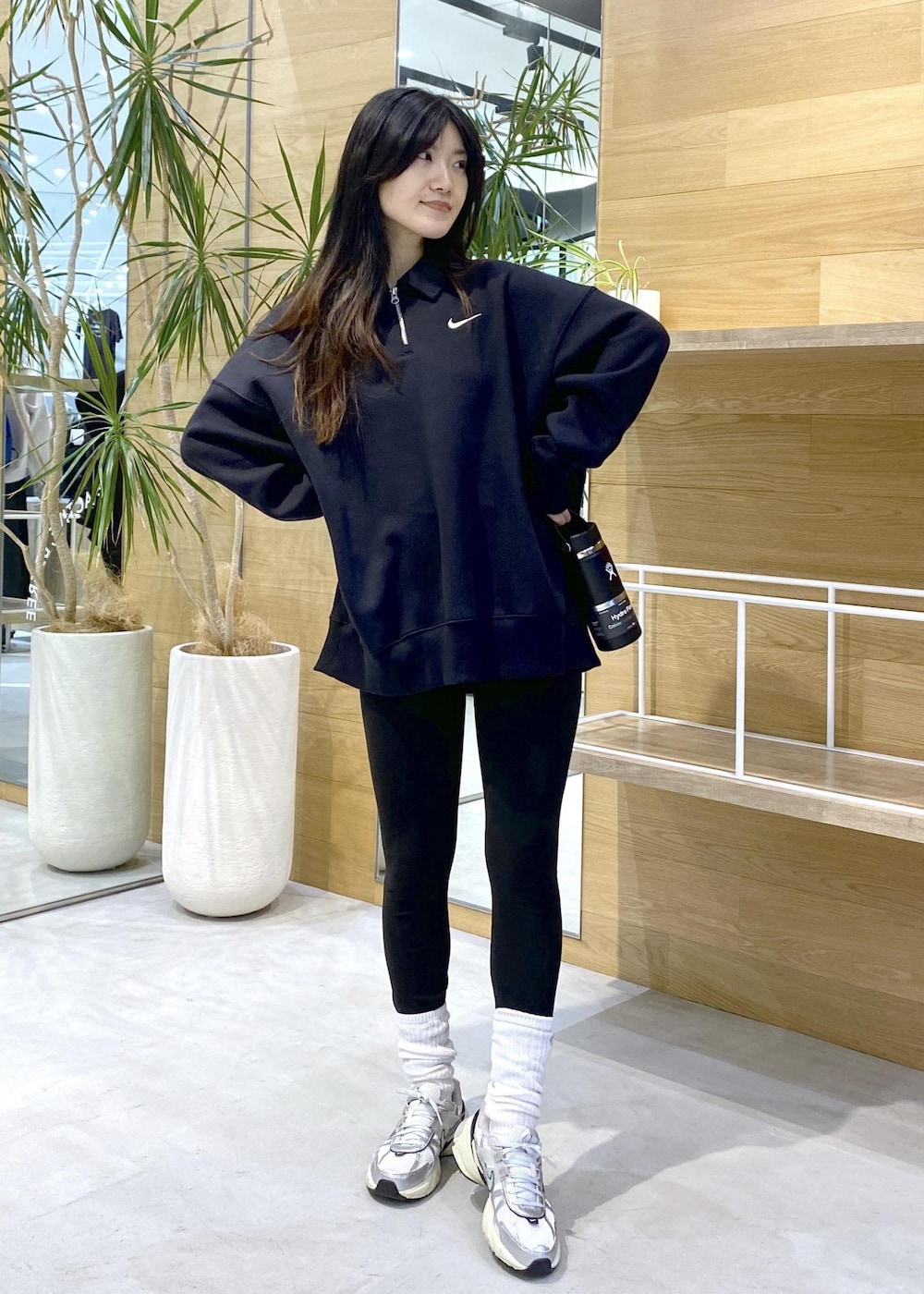ホワイト系のスニーカー、ブラック系のスウェット、ブラック系のレギンス/スパッツを着用したレディースの秋コーディネートの2枚目の写真