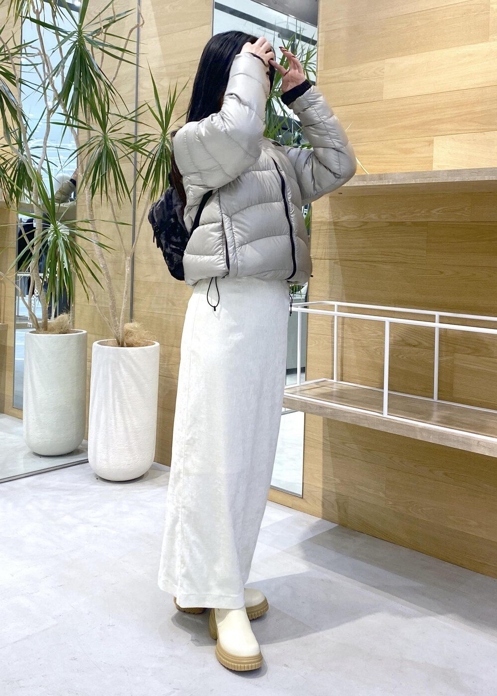 ベージュ系のダウンジャケット/コート、ホワイト系のブーツ、ホワイト系のスカートを着用したレディースの冬コーディネートの5枚目の写真