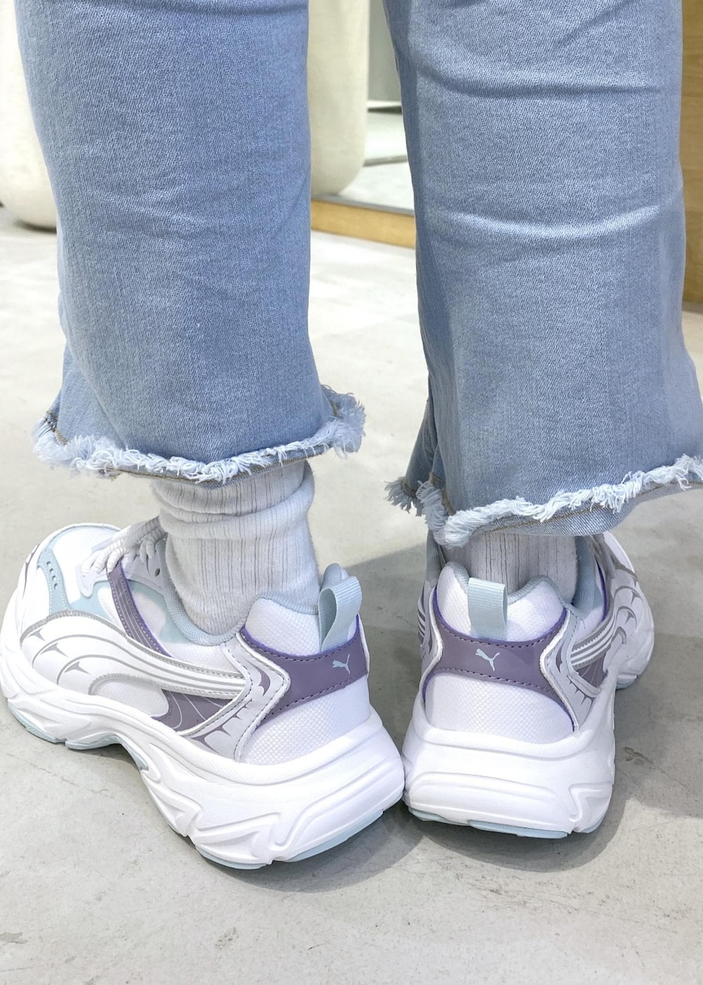 ホワイト系のアンサンブル、ブルー系のその他パンツ、ホワイト系のスニーカーを着用したレディースの秋コーディネートの8枚目の写真